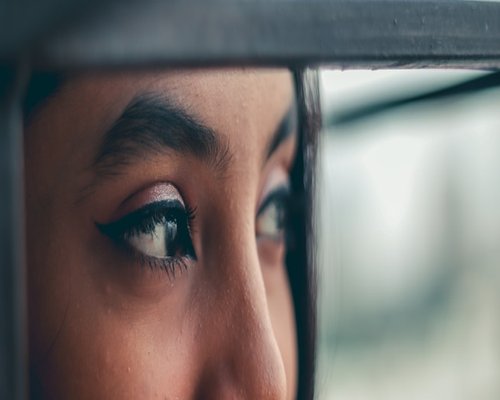 A person taking a break, looking out of a window to rest their eyes