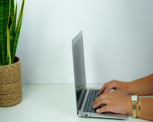 Person typing on a laptop maintaining a healthy distance from the screen